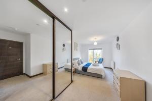 ein Schlafzimmer mit einem Bett und einer Glasschiebetür in der Unterkunft Stylish Kent apartment in Maidstone + 13 Fotos