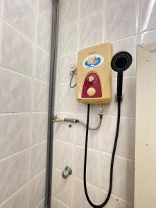 a shower with a hair dryer on a wall at IF Homestay Mersing in Mersing +24 photos