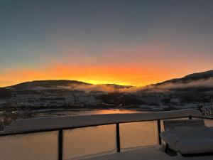 a view of a city in the snow at sunset at Botanisk Spa-retreat - Badstue & Foss - Magisk sted in Vossevangen