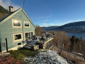 a house with a deck with a view of a lake at Botanisk Spa-retreat - Badstue & Foss - Magisk sted in Vossevangen