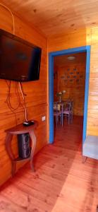 ein Wohnzimmer mit Flachbildfernseher und Tisch in der Unterkunft Cabaña punta de Lobos in Pichilemu