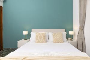 a bedroom with a large white bed with two lamps at Central Cagliari by Propertize in Cagliari