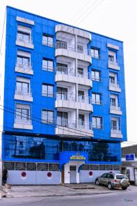 Résidence Belmann في دوالا: مبنى ازرق تقف امامه سيارة