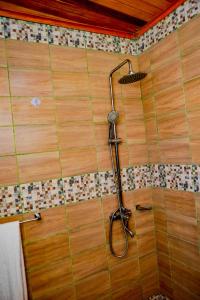 a shower with a shower head on a wall at Milo & Aby Resort, Le Mar in Kribi