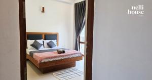 een slaapkamer met een bed en een deur naar een kamer bij nelli house in Galle