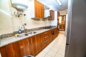 Résidence Belmann في دوالا: مطبخ مع خزائن خشبية ومغسلة