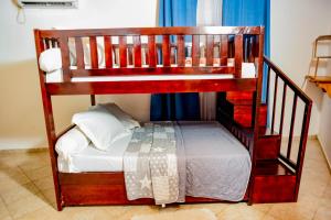 a wooden bunk bed with white sheets and a white bed at Milo & Aby Resort, Le Mar in Kribi +15 photos