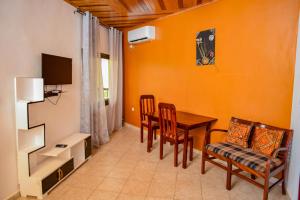 a living room with a dining room table and chairs at Milo & Aby Resort, Le Mar in Kribi