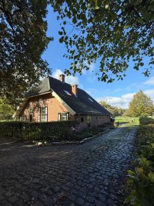 a brick house on a cobblestone street at Nanas Scheune in Lage