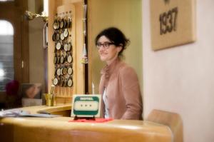 a woman standing behind a table with a clock on it at Hotel Panoramique in Torgnon