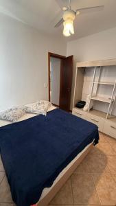 a bedroom with a large bed with a blue blanket at Cobertura duplex Bombas in Bombinhas