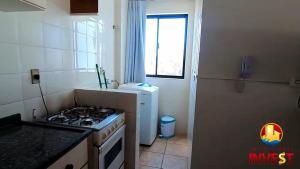 a kitchen with a stove and a sink and a window at Cobertura duplex Bombas in Bombinhas