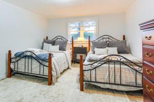 SunapeeLakefront Cabin with Panoramic Water View and Access的有两张床和一扇窗户的卧室