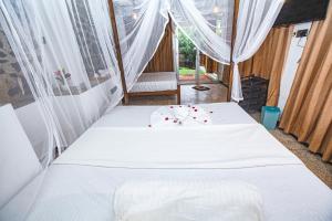 1 dormitorio con 1 cama con sábanas y cortinas blancas en Wow Reef Break, en Dondra West