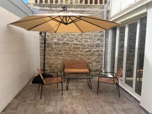 a patio with a table and chairs under an umbrella at Plus in Logroño