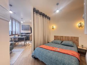 a bedroom with a bed and a living room at Le Sweety - Studio - 1 lit - 2 personnes in Châtel-Guyon