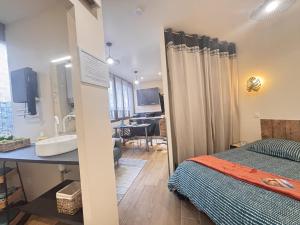 a room with a bed and a sink and a bathroom at Le Sweety - Studio - 1 lit - 2 personnes in Châtel-Guyon