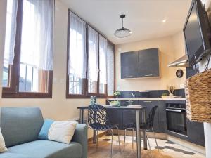 a living room with a couch and a table in a kitchen at Le Sweety - Studio - 1 lit - 2 personnes in Châtel-Guyon +4 photos