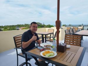 a man sitting at a table with a plate of food at Fini Palace in Ma Faro