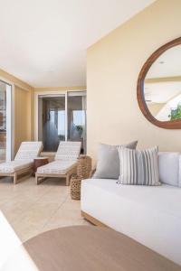a living room with a white couch and a mirror at Luxury Oceanview Condo Steps to El Anclote in Punta Mita