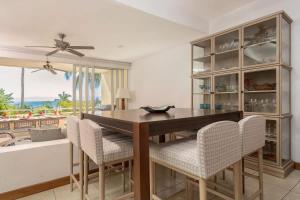 a dining room with a wooden table and chairs at Luxury Oceanview Condo Steps to El Anclote in Punta Mita