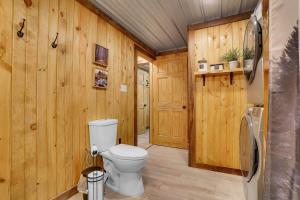a bathroom with a toilet and wooden walls at The Elk Camp in Benezette +37 photos