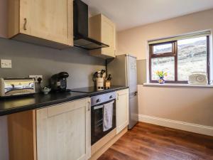 a kitchen with a sink and a stove top oven at Baywood Cottage in Keighley
