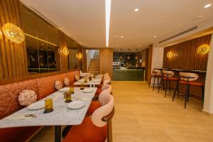 a restaurant with long tables and chairs and a bar at Dally Apart Hotel in Rabat