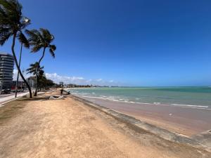 a sandy beach with palm trees and the ocean at Ametista 2 Beira Mar in Maceió