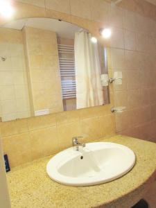 bagno con lavandino bianco e specchio di Asen 36 Apartment a Sofia