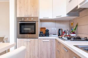 a kitchen with wooden cabinets and a microwave at Lime Calabria Apartment in Falerna Marina
