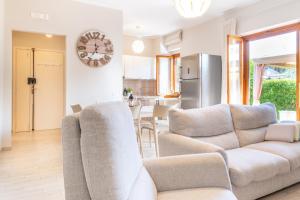 a living room with two couches and a kitchen at Lime Calabria Apartment in Falerna Marina