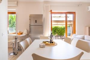 Una cocina y un comedor con una mesa y sillas blancas. en Lime Calabria Apartment, en Falerna Marina