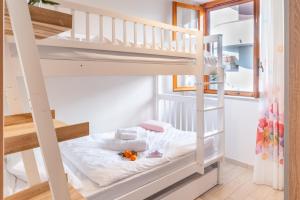 a bunk bed in a small room with a ladder at Lime Calabria Apartment in Falerna Marina +10 photos