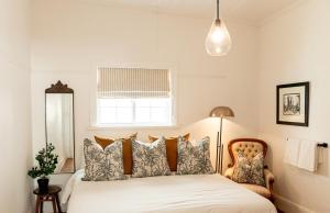 Cottage at 48 في غراف-رينيت: غرفة نوم بها سرير مع وسائد ونافذة