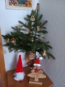 a christmas tree on a table with two gnomes under it at Ferienhaus Töpferblick-Hartau in Hartau