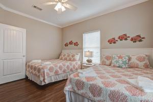 ein Schlafzimmer mit zwei Betten und einem Deckenventilator in der Unterkunft Crystal Moon in Crystal Beach