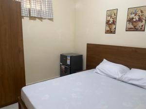 Schlafzimmer mit einem weißen Bett und einem schwarzen Lautsprecher in der Unterkunft Résidence Keur Mame Seye 3 in Dakar + 4 Fotos