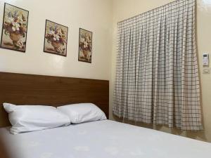 ein Schlafzimmer mit einem weißen Bett und einem Fenster in der Unterkunft Résidence Keur Mame Seye 3 in Dakar