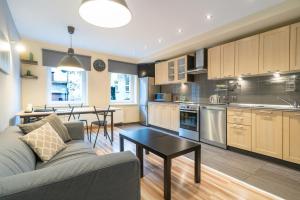 a kitchen and living room with a couch and a table at Katowice Central Apartment by BookingHost in Katowice +22 photos