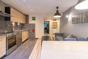 a kitchen and living room with a couch and a table at Katowice Central Apartment by BookingHost in Katowice