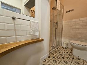 a bathroom with a toilet and a glass shower at Il Leoncino Loft con vista sulla Piazza in Pistoia +7 photos