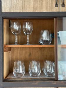 uma fileira de taças de vinho em uma prateleira em 豊橋民泊 最大13名様 駐車場2台無料 駅徒歩7分 Traditional Japanese house ,Toyohashi Aichi ,7 minutes walk from the station ,2 free parking em Toyohashi