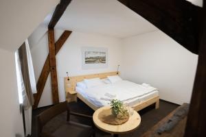a small bedroom with a bed and a table at Zámecká Konírna Hotel a Restaurace in Liberec +11 photos