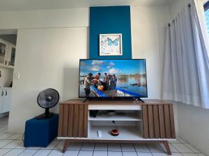 a television on a stand in a living room at Ametista 2 Beira Mar in Maceió