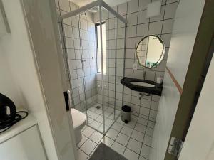 a small bathroom with a toilet and a mirror at Ametista 2 Beira Mar in Maceió