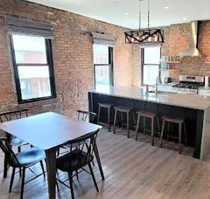 uma cozinha com mesa e cadeiras em uma sala em Jungle House Columbus Downtown Free Parking Sleeps 8 - Steps to Convention Center & Nationwide Arena - 2BR Short North Luxury Home - Over 5,800 Five Star Stays em Columbus