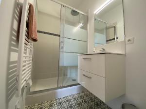 a white bathroom with a shower and a sink at V2 Studio avec balcon, plein centre - 5 min Golfech in Valence-dʼAgen