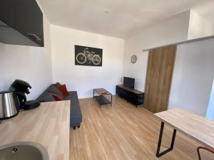 a living room with a couch and a table at V2 Studio avec balcon, plein centre - 5 min Golfech in Valence-dʼAgen