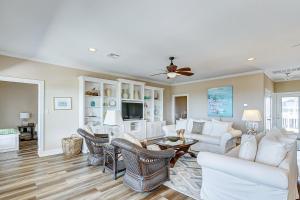 een woonkamer met witte meubels en een plafondventilator bij CoCo Beach in Crystal Beach